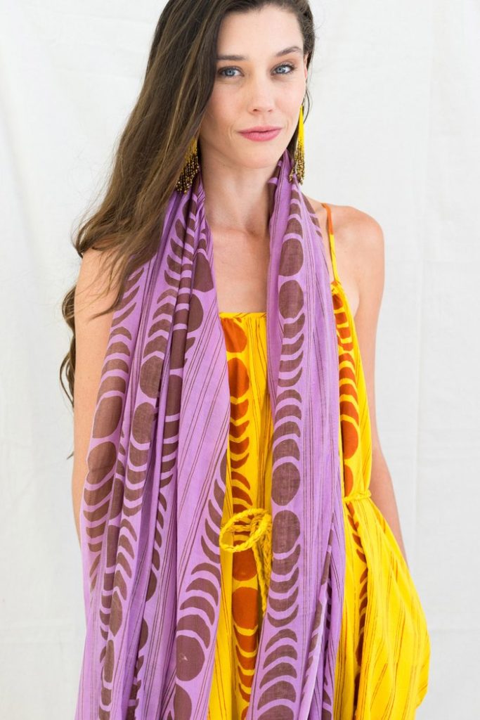 White woman in a yellow dress wearing a lilac Onikas Block-Printed Scarf
